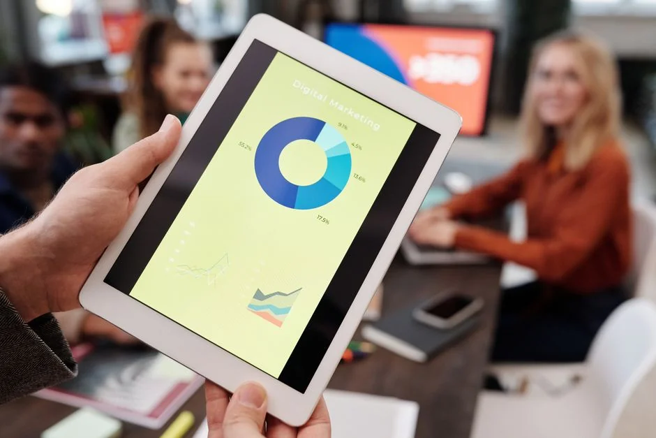 who-we-are A top-down view of an e-commerce chart, with a smartphone, calculator, and magnifying glass laid out on a table.